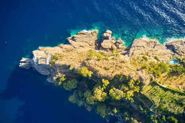 意大利波尔图菲诺港一座灯塔的顶部景观 灯塔矗立在靠近大海的岩石山上 蓝色碧绿的海水映衬着它 利古里亚的大海用大石头冲刷着海岸 — 图库照片
