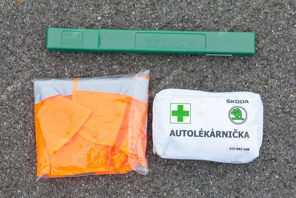 First aid, safety orange vest and green road sign in the car from Skoda Auto on a asphalt road. Emergency tool kit for the first help after car accident, Prague, March, 2020.