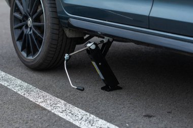 Jack bir araç kaldırıyor. Otomobil servisi. Lastik değiştirme konsepti, Prag, Mart 2020