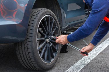 Adamların ellerini kapat. Tekerlek usinf srewdriver değiştiriyor. Kış ve yaz lastikleri değiştiriliyor. Mevsimlik lastik değiştirme konsepti. Hizmet süreci. Prag, Mart 2020