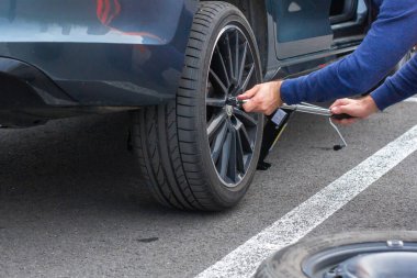 Adamların ellerini kapat. Tekerlek usinf srewdriver değiştiriyor. Kış ve yaz lastikleri değiştiriliyor. Mevsimlik lastik değiştirme konsepti. Hizmet süreci. Prag, Mart 2020