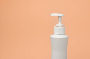 Turuncu arka planda şeker kutusuyla beyaz şişeyi taklit et. Kozmetik ambalajı. Kozmetik ürün reklamı için boşluk kopyala