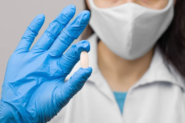Ένα Χάπι Στο Χέρι Μπλε Γάντια Γυναίκα Κρατά Ένα Φάρμακο — Φωτογραφία Αρχείου
