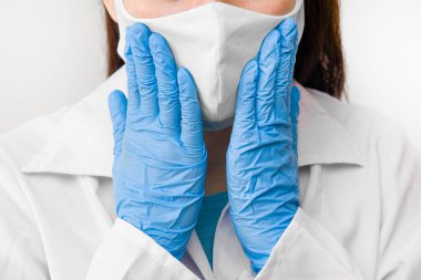 Koronavirüs, SARS-CoV-2, 2019-NCoV ya da gribe karşı koruyucu maskeli kadınlar. Beyaz önlüklü doktor, mavi eldivenli ve maskeli.