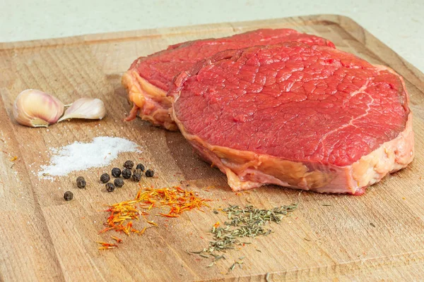 Rohes Fleisch Auf Einem Holztisch Mit Knoblauch Salz Schwarzem Pfeffer — Stockfoto