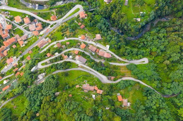 Vue en angle élevé des maisons avec des toits rouges sur les arbres au sommet de la montagne en été. Vue ariale sur la montagne village italien — Photo