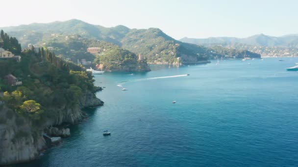 Imágenes aéreas del sellado de lanchas a motor en el Mar de Liguria en Portofino, Italia. Costanera rocosa y agua de mar azul . — Vídeo de stock