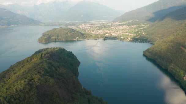 Flygbilder av Comosjön med två öar i mitten. Reflektion av ett moln i ett blått vatten vid solnedgången. Sjön omgiven av Alperna, Italien. — Stockvideo