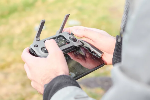 Close up mani mans tenendo drone telecomando con smartphone sul campo. Concetto di tiro aereo e volo, San Francisco, maggio 2020 . — Foto Stock
