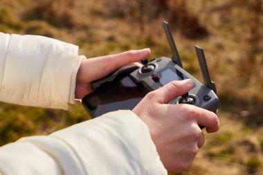 Kadınların ellerini yakın tut, uzaktan kumandayı akıllı telefonla tut. Hava görüntüsü kavramı, San Francisco, Mayıs 2020