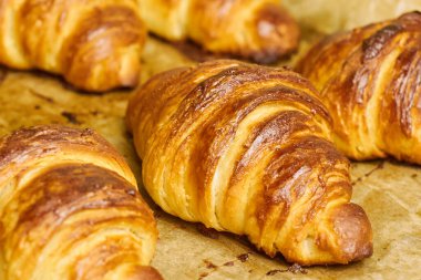 Fırından tereyağlı kruvasanlar fırın tepsisiyle çıkarılmış. Ev yapımı hamur işi kavramı. İtalyan ya da Fransız geleneksel kahvaltısı