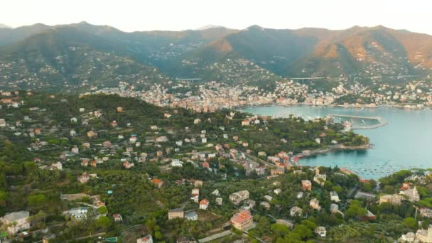 Luchtbeelden van een haven met schepen Santa Margherita Ligure met bergen op de achtergrond, vlakbij Portofino. Zonsondergang in de Italiaanse Riviera. — Stockvideo