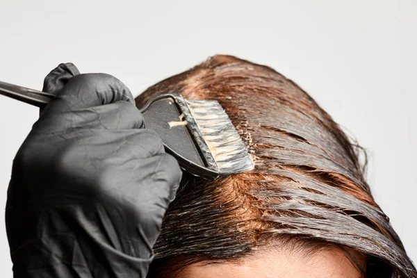 Primeros planos mujer manos teñir el cabello con un cepillo negro. Coloración del cabello blanco en casa . —  Fotos de Stock