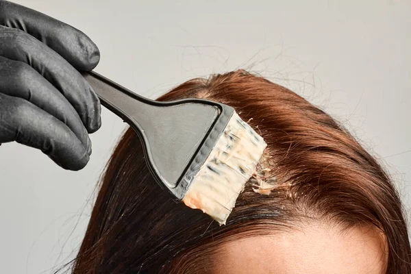 Nahaufnahme Frau Hände Haare färben mit einem schwarzen Pinsel. Färbung der weißen Haare zu Hause. — Stockfoto