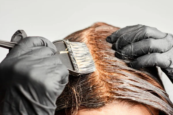 Primeros planos mujer manos teñir el cabello con un cepillo negro. Coloración del cabello blanco en casa . —  Fotos de Stock