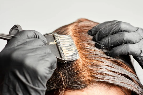 Nahaufnahme Frau Hände Haare färben mit einem schwarzen Pinsel. Färbung der weißen Haare zu Hause. — Stockfoto