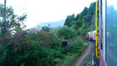 Dağ yamaçlarında hareket eden tren, güzel bir manzara, bir yamaç dağı, bir vadi. Hindistan 'da Shimla' dan Kalka 'ya giden oyuncak tren.