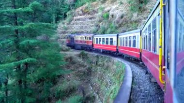 Dağ yamaçlarında hareket eden tren, güzel bir manzara, bir yamaç dağı, bir vadi. Hindistan 'da Shimla' dan Kalka 'ya giden oyuncak tren.