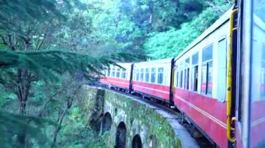 Dağ yamaçlarında hareket eden tren, güzel bir manzara, bir yamaç dağı, bir vadi. Hindistan 'da Shimla' dan Kalka 'ya giden oyuncak tren.