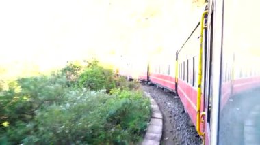 Dağ yamaçlarında hareket eden tren, güzel bir manzara, bir yamaç dağı, bir vadi. Hindistan 'da Shimla' dan Kalka 'ya giden oyuncak tren.