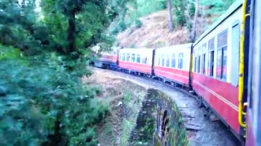 Dağ yamaçlarında hareket eden tren, güzel bir manzara, bir yamaç dağı, bir vadi. Hindistan 'da Shimla' dan Kalka 'ya giden oyuncak tren.
