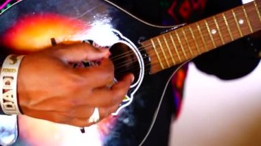 Ludhiana, Punjab, Hindistan 'da gitar çalan bir adamın elleri kapalı.