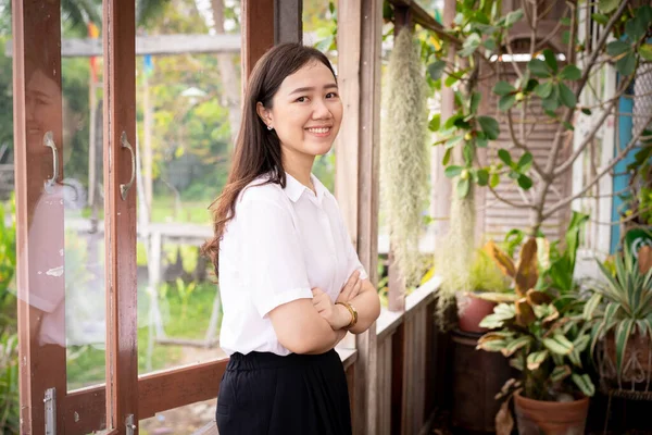 Beautiful Asian woman\'s portrait in the indoor garden house. Happy woman smiling close up.