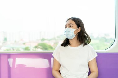 Kalabalık yerlerde dolaşırken COVID19 virüsünü ve PM2.5 kirliliğini korumak için hijyen koruyucu maske takan bir kadın. Kadın Asya ülkesindeki Corona virüsünü korumak için yüz maskesi kullanıyor. Hastalık.