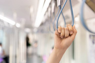 Kadın turist şehir gökyüzü tren sistemi ile şehre seyahat ediyor. Trende tırabzanı tutan kadın fotokopi alanıyla yakın çekim yapıyor. Modern yaşam tarzı konseptinde yalnız kadın turist. Kentsel yaşam tarzı.