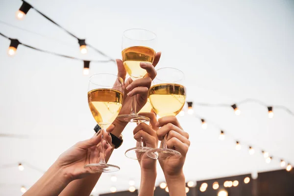 Partiye katılan ve beyaz şarapla kutlama yapan bir grup insan. Mutlu Asyalılar festivalde eğlenmeyi ve 5 yıldızlı otelin çatı katında beyaz şarapla kutlamayı severler..