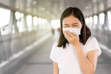 COVID19 virüsünü, COVID-19 'u ve PM2.5' u korumak için hijyen koruyucu maske takan bir kadın kalabalık bir yerde seyahat ediyor. Kadın, koronavirüs hastalığını korumak için yüz maskesi kullanıyor. 2019-nCov krizi.