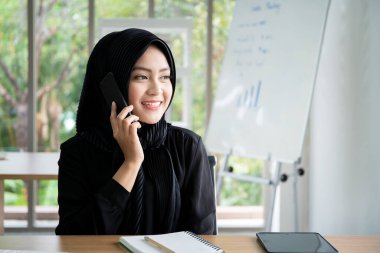 Ofiste çalışan güzel Asyalı Müslüman iş kadınının portresi, kültürel çeşitlilik ve cinsiyet kavramı.