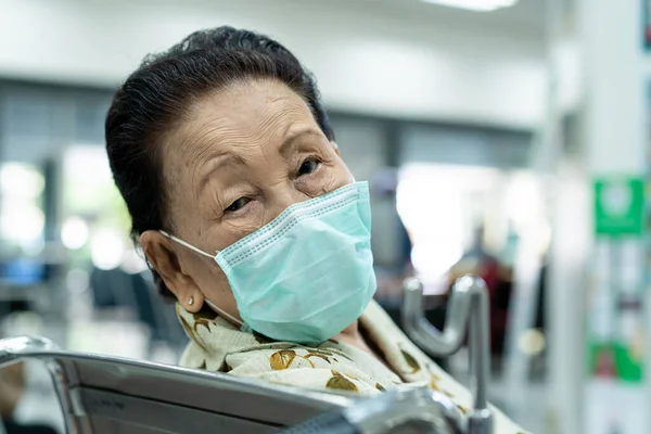 Nervous Asian elder woman age 80s waiting to meet doctor in the government hospital. Elder acting worried face during in the hospital. Asian grandmother age between 80-90 years old portrait.
