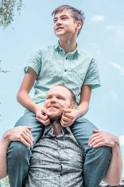 Boy sitting on dad shoulders
