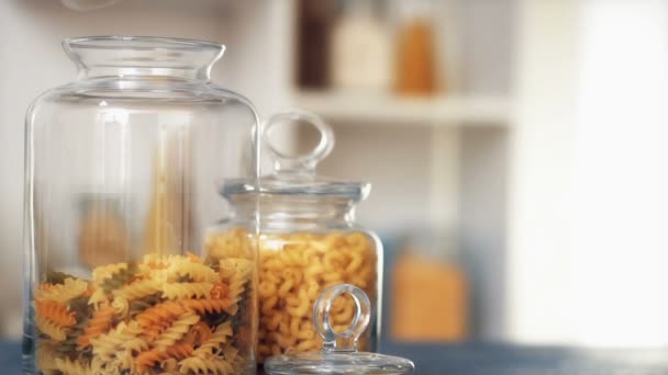 Pasta fall into a glass jar on white background — Stock Video