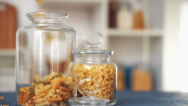 Pasta fall into a glass jar on white background — Stock Video