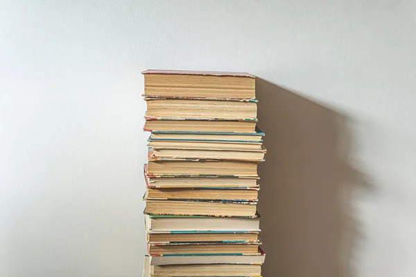 Stor hög med gamla böcker över vit vägg — Stockfoto