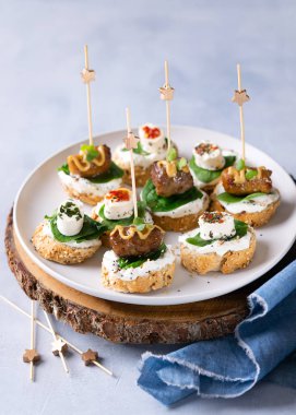 Atıştırmalıklar, mini kebaplar, krem peynir, otlar, ıspanak ve hardallı şişler ve yazı için boş alan. Parti parmak yiyeceği konsepti.