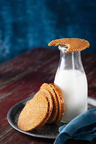Карамел Стропвафель, печиво Голландії з пляшкою молока, на сільському дерев'яному фоні, вибірковий фокус з копіюванням простору.. — стокове фото