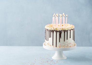 Doğum günü Drip Cake 'i çikolatalı ganache ve arkaplanda hafif bir afişle süslenmiş pembe mumlarla dolu. Uzayı kopyala Kutlama konsepti. Moda Damlatma Keki. Seçici odak.