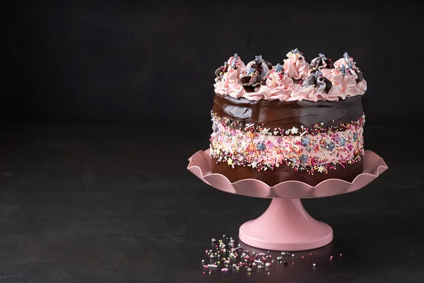 誕生日ケーキでスプリンクル付き茶色の背景に鏡面スペース — ストック写真