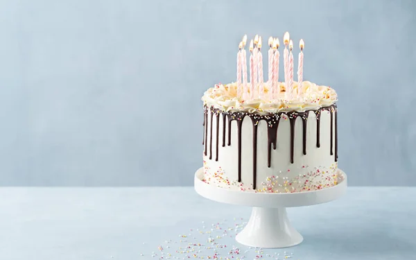 バナーケーキ 誕生日ドリップパーティーの装飾が施された明るい背景バナーにチョコレートガナッシュとスプリンクル付きピンクのキャンドルがたくさんあります コピースペース お祝いのコンセプト トレンディーなドリップケーキ 選択的焦点 — ストック写真