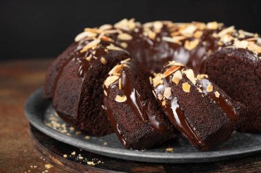 Çikolatalı keki dilimli, erimiş çikolatalı ve bademli kapayın. Seçici odak, yatay bileşim.