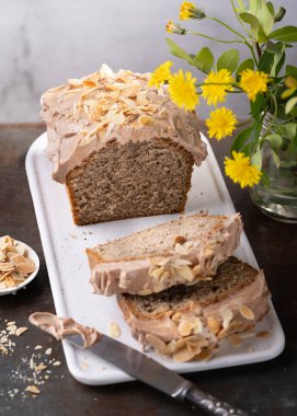 Kahve, moka kremalı somun kek ve sade arka planda badem, seçici odaklanma. Tatlı yemek. Tatlı tatlı. Kapat..