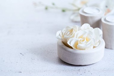 Çiçekli spa çiçekli sabun gülleri ve gri arka planda çimento gri mumlar ve fotokopi alanı ile kompozisyon. Seçici odaklanma. Wabi sabi, minimalizm.