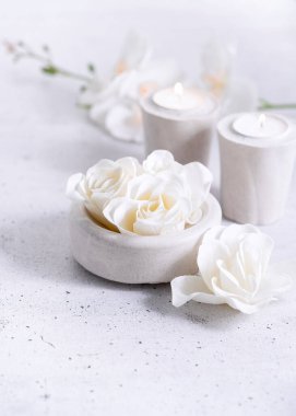 Çiçekli spa çiçekli sabun gülleri ve gri arka planda çimento gri mumlar ve fotokopi alanı ile kompozisyon. Seçici odaklanma. Wabi sabi, minimalizm, tek renkli arkaplan.
