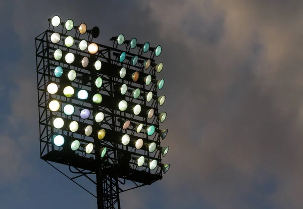 Lights on in one of the light towers of a sports stadium