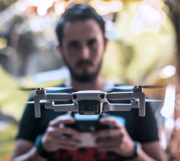 Front closure of the Mavic Mini drone flying over a person who controls it with his remote control