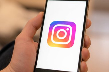 Miami / ABD - 19 Şubat 2020: Ekranda sosyal medya Instagram logosu olan siyah telefon. Sosyal medya ikonu. Telefonla el ele. Pazarlama veya iş konsepti için illüstrasyon olarak kullanılabilir