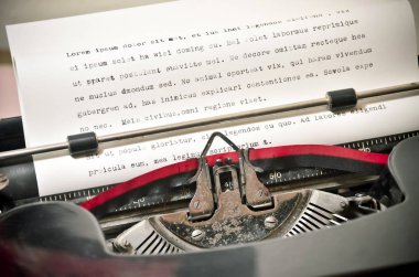 Close Up of Antique Typewriter with Ribbon Typing Lorem Ipsum clipart